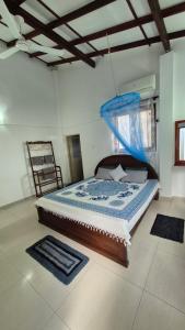 a bedroom with a bed with a mosquito net at NATIVE SOULS Beach Hotel in Induruwa
