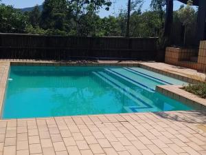 a swimming pool with blue water in a backyard at Harnham Mountain Lodge in Elsteg