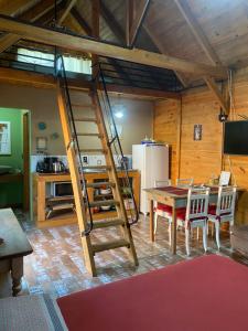 a room with a table and a ladder in a kitchen at Chalé Alpino Apiúna in Apiúna +12 photos