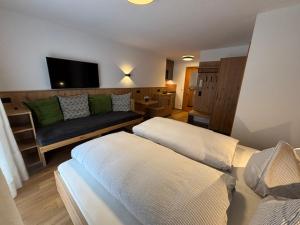 a living room with two beds and a couch at Alpenrösle Ferienwohnungen - Berge - Ruhe - Traumaussicht 1-, 2- und 3-Raum-Wohnungen, Panoramasauna in Balderschwang