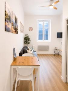 a living room with a table and a couch at Escapade Provencale in Lectoure