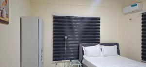 a small bedroom with a bed and a window at TEE Guest House in Monrovia
