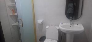 a bathroom with a sink and a toilet and a mirror at TEE Guest House in Monrovia +8 photos