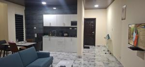 a living room with a blue couch and a kitchen at TEE Guest House in Monrovia