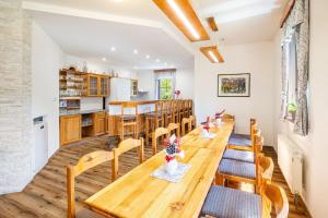 a kitchen and dining room with wooden tables and chairs at Chalupy Na Rališce in Horní Bečva