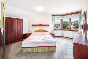 a bedroom with a bed and a large window at Chalupy Na Rališce in Horní Bečva