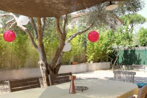 a table with red lanterns and a tree at RDC dans maison "ilolil" a 1km plage de la Coudoulière in Six-Fours-les-Plages