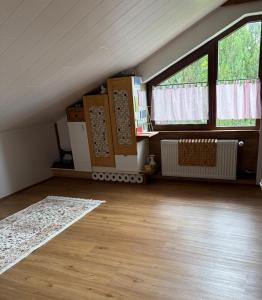an attic room with two windows and a wooden floor at Sunrise Loft in Bingen am Rhein