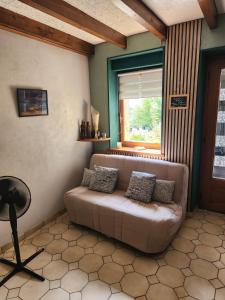 a living room with a couch and a window at Les Souchottes, charmante maisonnette in Bulligny