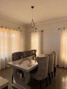 a dining room with a white table and chairs at MAI instahomes in Lilongwe