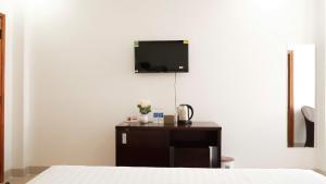 a bedroom with a bed and a tv on the wall at Hila Hotel Vạn Ninh in Vạn Ninh