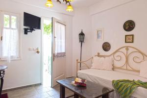a bedroom with a bed and a table and a tv at Villa Areto in Kamares