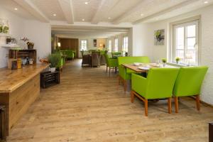 a dining room with green chairs and a table at Dahlbrucher Hof in Hilchenbach