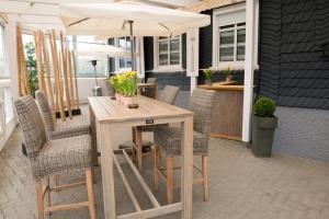 a table and chairs with an umbrella on a patio at Dahlbrucher Hof in Hilchenbach +8 photos