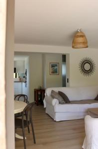 a living room with a white couch and a table at RDC dans maison "ilolil" a 1km plage de la Coudoulière in Six-Fours-les-Plages