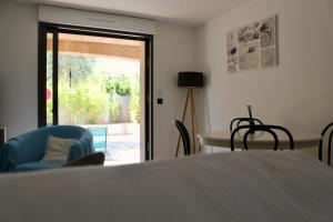 a living room with a table and chairs and a sliding glass door at RDC dans maison "ilolil" a 1km plage de la Coudoulière in Six-Fours-les-Plages +16 photos