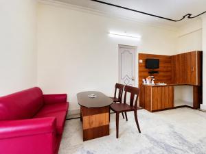 a living room with a red couch and a table at The Binapani Hotel And Restaurant in Tarapith +39 photos