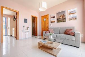 a living room with a couch and a coffee table at Il-Kannizzata luxurious Gozo penthouse with sea view & pool in Għajnsielem