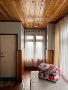 a bedroom with a bed and a window and a door at Chyajalo homestay in Darjeeling