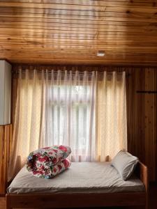 a bed in a room with a window at Chyajalo homestay in Darjeeling