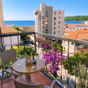 a balcony with a table and wine glasses on it at Apartments Bloom Bečići in Bečići