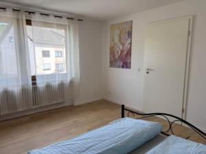 a white room with a bed and a window at Ferienwohnung Arend in Nonnweiler