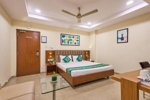 a hotel room with a bed and a desk and a bed sidx sidx at Treebo Landmark in Visakhapatnam +33 photos