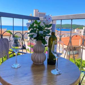 a table with a bottle of wine and two glasses at Apartments Bloom Bečići in Bečići