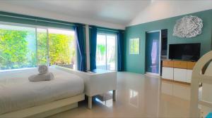 a bedroom with a bed and a large window at Bann Sunset Cove Krabi I A Hidden Luxury Escape on Had Yao Beach in Krabi