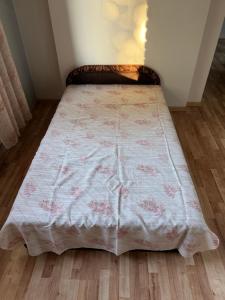 a bed with a blanket on top of a wooden floor at 40m2 apartmnet in Viljandi