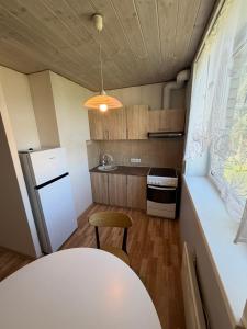 a small kitchen with a white refrigerator and a table at 40m2 apartmnet in Viljandi