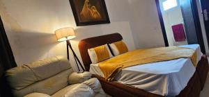 a bedroom with a bed and a couch and a lamp at Very comfortable apartment in Hajreien