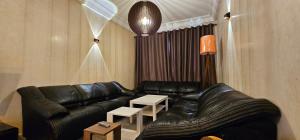 a living room with a black leather couch and tables at Very comfortable apartment in Hajreien