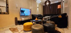 a living room with black leather furniture and stools at Very comfortable apartment in Hajreien