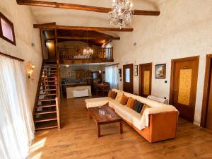 a living room with a couch and a chandelier at ALPE LUXURY ACCOMMODATION Penelope Collection in Olympiada