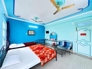 a bedroom with blue walls and a bed and a table at The Binapani Hotel And Restaurant in Tarapith