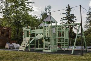 ein grüner Spielplatz mit Rutsche im Garten in der Unterkunft BOHO HOUSE in Ustrzyki Dolne