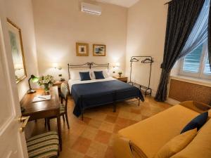 a bedroom with a bed and a table and a couch at Palazzo Sottile Meninni - CLASSIC ROOMS EXPERIENCE in Gravina in Puglia +67 photos