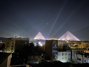 a view of the pyramids of a city at night at Prince Pyramid HoteLL in Cairo