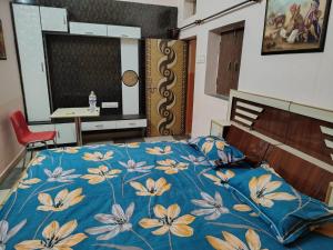 a bedroom with a bed with a blue blanket with flowers at Mi HOMESTAY in Bikaner