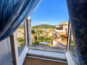 a window with a view of a city at Palazzo Sottile Meninni - CLASSIC ROOMS EXPERIENCE in Gravina in Puglia