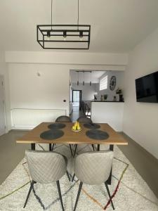 a dining room with a wooden table and chairs at Apartament Debres Concept in Aiud