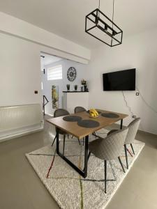 a dining room with a wooden table and chairs at Apartament Debres Concept in Aiud