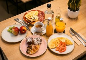 a table with plates of breakfast food on it at Hotel Casa Gardenia by Blossom Hotels in Barcelona