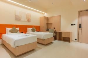 a hotel room with two beds and a desk at Casa Hotel Hitech City in Hyderabad