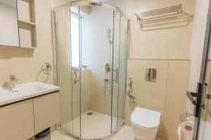 a bathroom with a shower and a toilet and a sink at Casa Hotel Hitech City in Hyderabad