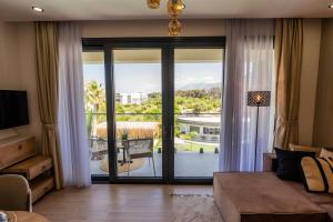a living room with a large glass door to a balcony at Palmera Resort Wellness & Spa - Mountain & Pool View Studio 1 by Azur Prime in Vasilia