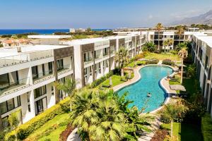 an aerial view of a resort with a pool and palm trees at Palmera Resort Wellness & Spa - Mountain & Pool View Studio 1 by Azur Prime in Vasilia