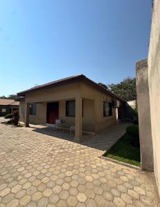 a house with a brick driveway in front of it at JAYNIEL Apartments #2 in Lusaka