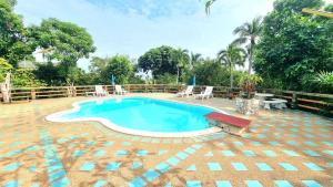 a pool in a yard with chairs and a table at Floral House in Lamai